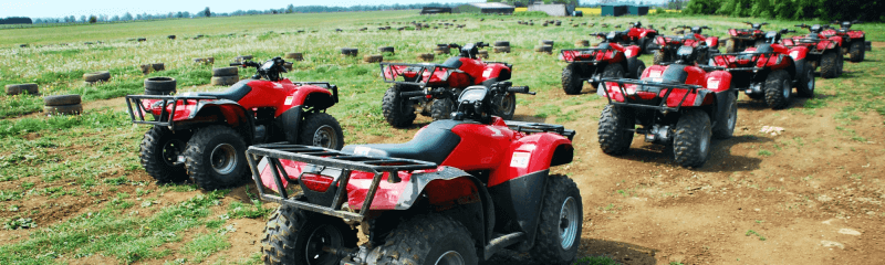 Quad Bike Safari in Leicester, red quad bikes lined up on an obstacle-filled terrain at Avalanche's activity centre